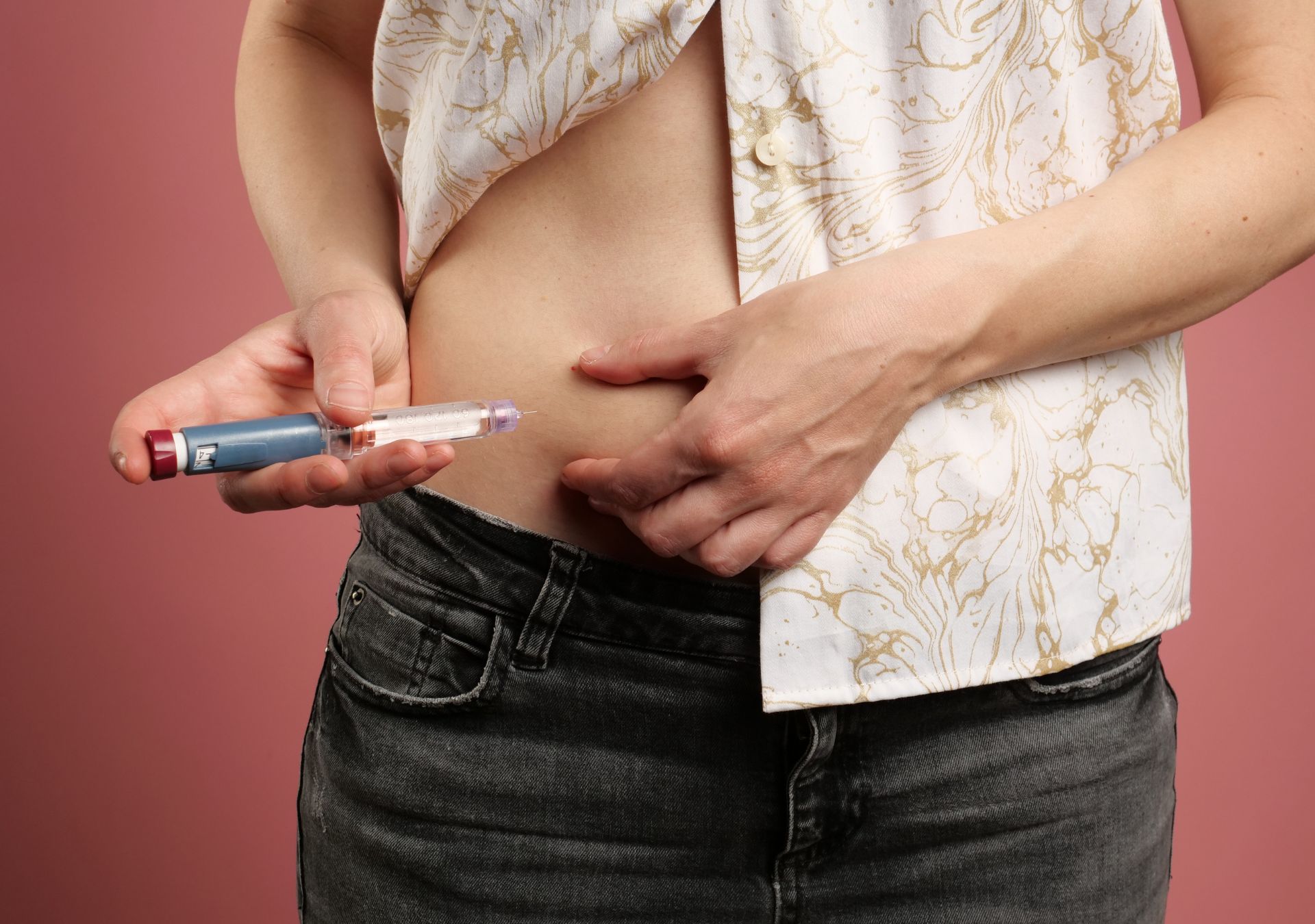 Person spritzt sich mit einem Injektionspen eine Abnehmspritze in den Bauch zur Behandlung von Diabetes Typ 2