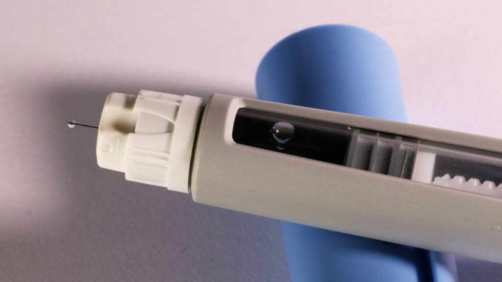 Nahaufnahme einer Semaglutid Abnehmspritze mit sichtbarer Nadel und Medikamententropfen – Anwendung zur Gewichtsreduktion und Diabetesbehandlung