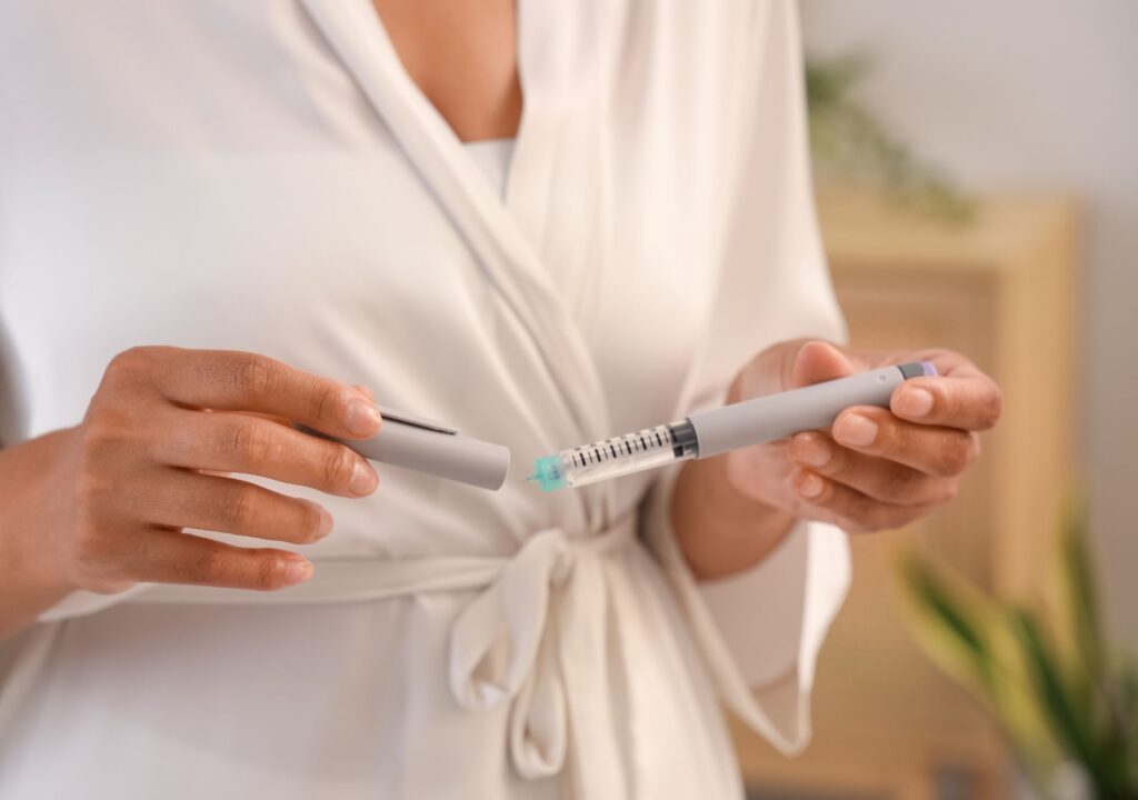 Frau hält Abnehmspritzen-Pen in der Hand – Symbol für medizinische Wirksamkeit und Investition in Gesundheit