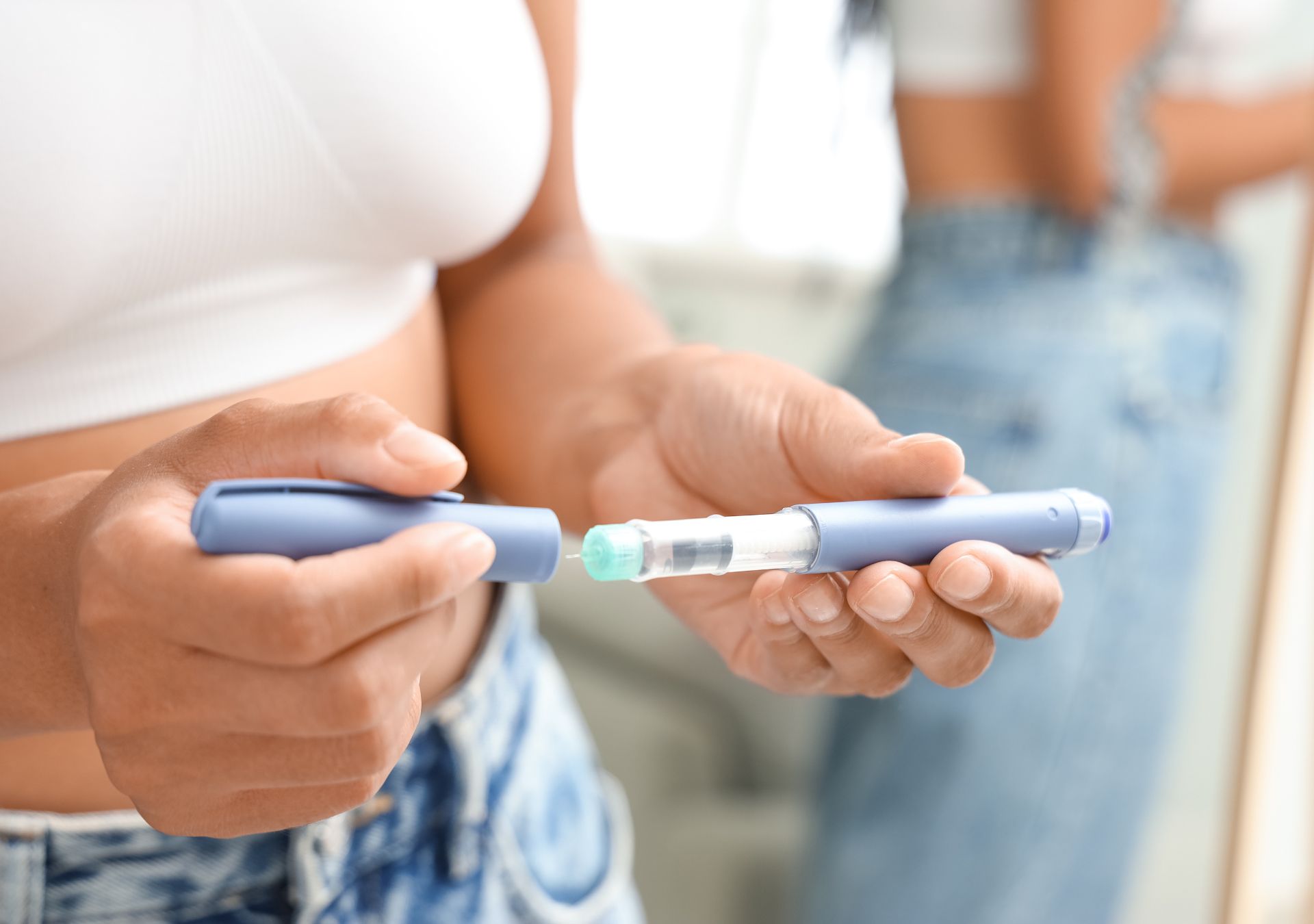 Frau hält eine Abnehmspritze in der Hand – Beispiel für medizinische Anwendung bei Adipositas, bevor die Krankenkasse über Kostenübernahme entscheidet