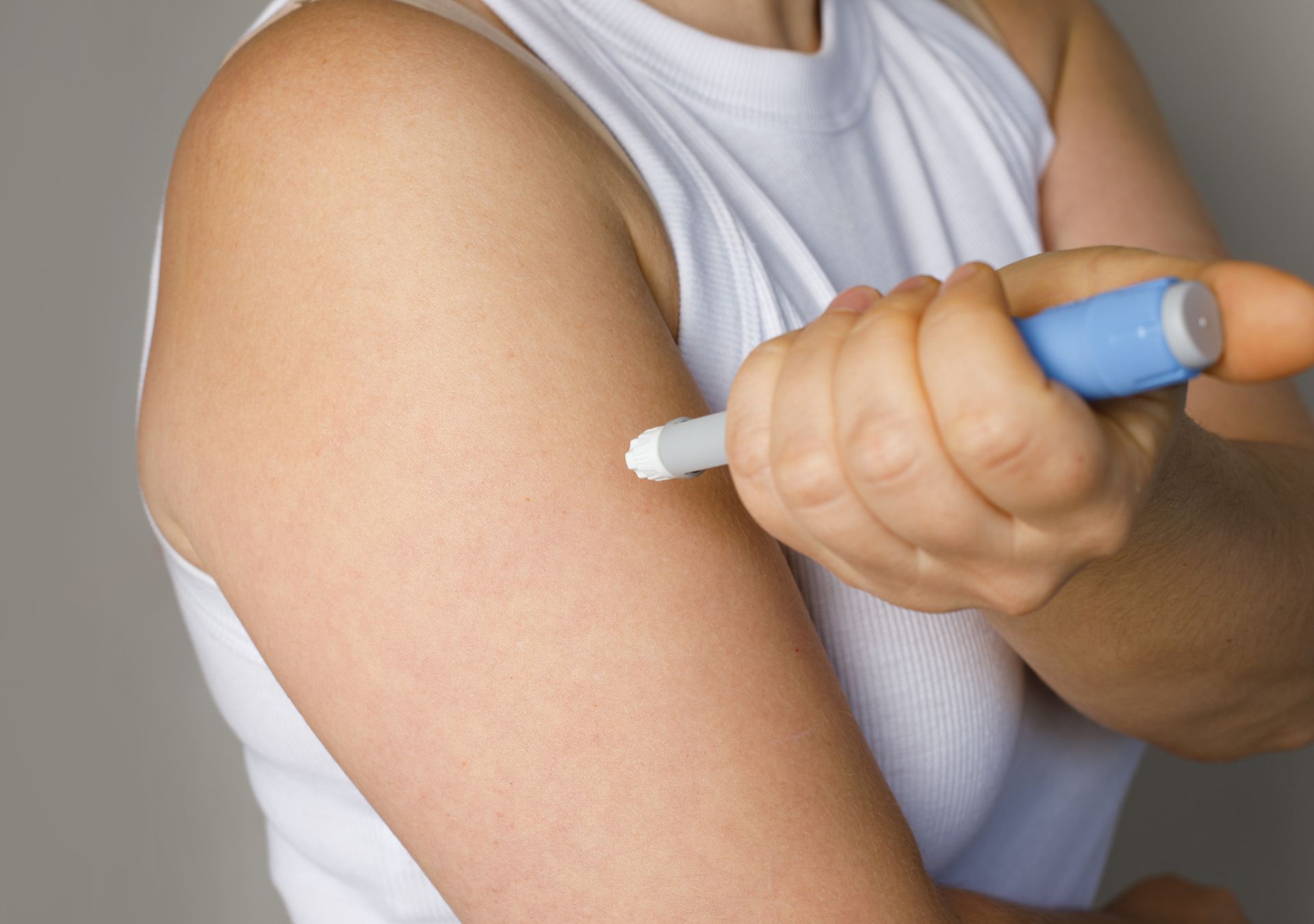 Frau spritzt sich Semaglutid mit einem Injektionspen in den Oberarm zur Gewichtsreduktion