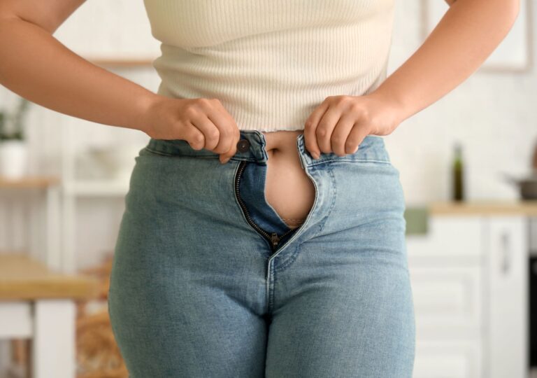 Frau steht nach Gewichtsverlust auf Waage, nachdenklich – Symbolbild für Jo-Jo-Effekt nach Wegovy-Absetzen